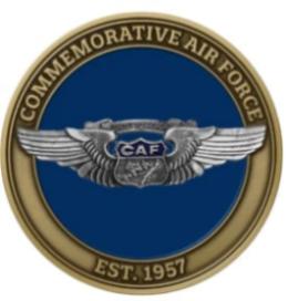 A round challenge coin with a blue background featuring the text 'COMMEMORATIVE AIR FORCE' and 'EST. 1957'.