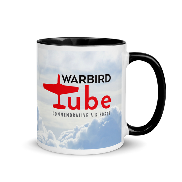 A ceramic mug with a white body and black handle, featuring the text 'WARBIRD commerative air force' along with an image of an airplane in flight.