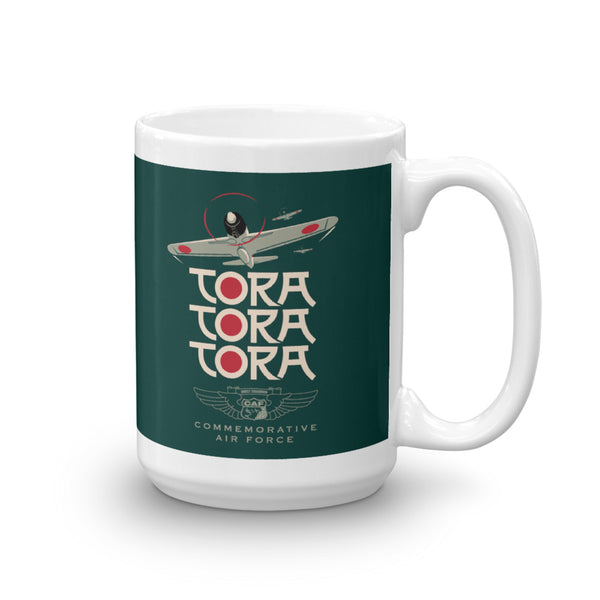 A ceramic mug with a green background featuring a graphic with the text 'TORA TORA TORA' and an illustration of an airplane.