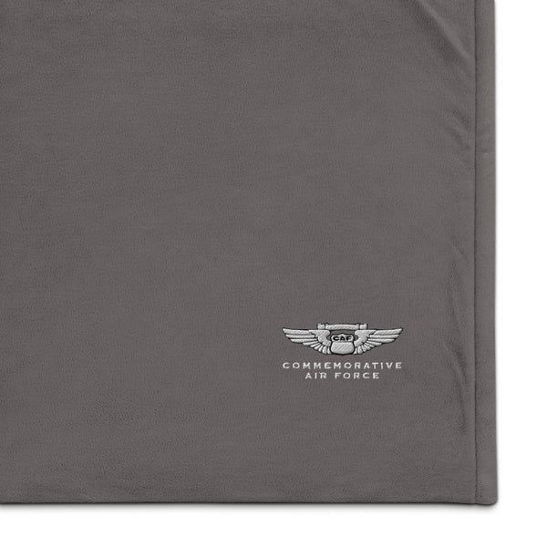 A plush gray Sherpa blanket with a corner embroidered with the CAF logo, featuring fleece fabric on one side and Sherpa fabric on the other.